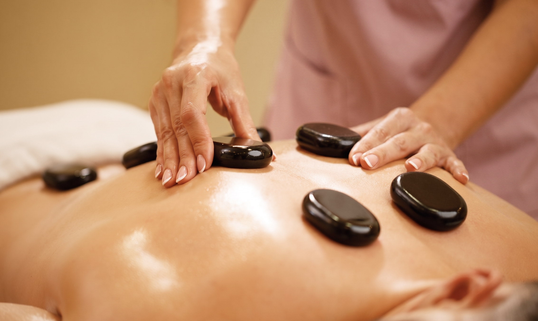 Client relaxing with hot stones placed on their back