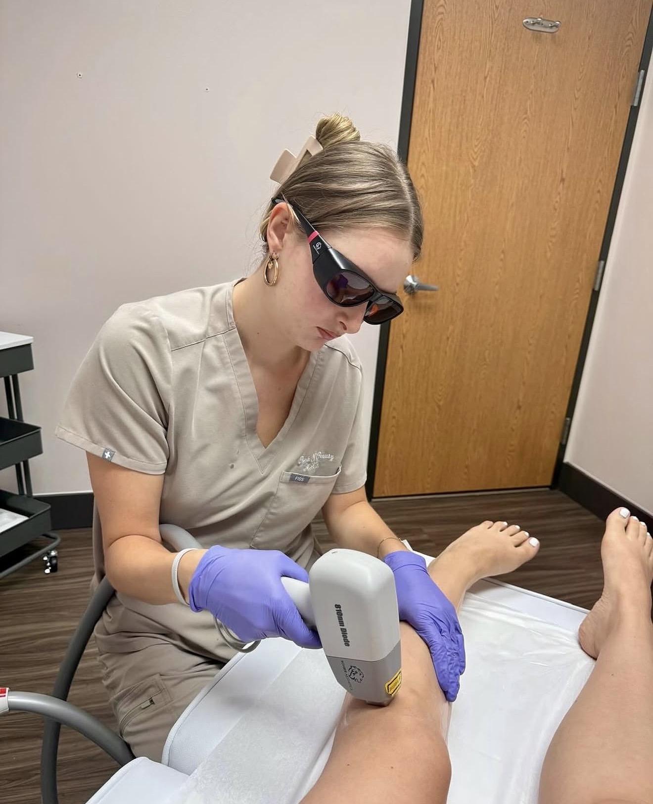 Technician performing IPL light therapy treatment on a client